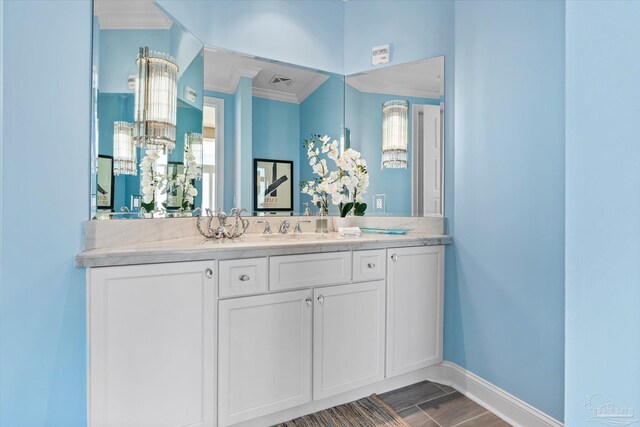 bathroom with crown molding, hardwood / wood-style flooring, and vanity