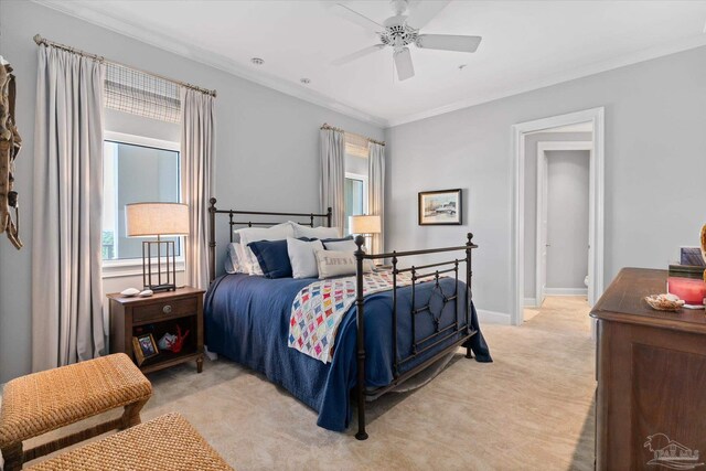 bedroom featuring ornamental molding, light colored carpet, and ceiling fan