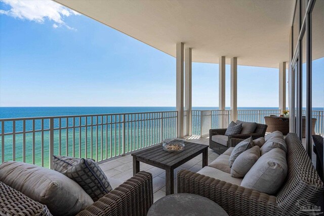 balcony featuring outdoor lounge area and a water view