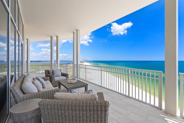 balcony with outdoor lounge area, a water view, and a beach view