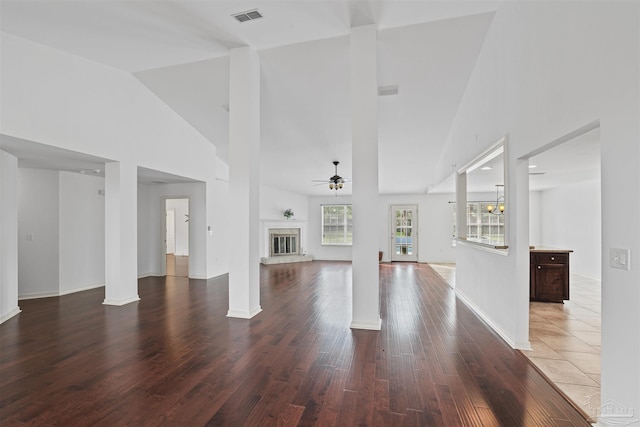 4810 Endeavor Ct, Milton, FL 32570 - unfurnished living room featuring ceiling fan, a glass covered fireplace, wood finished floors, high vaulted ceiling, and ornate columns