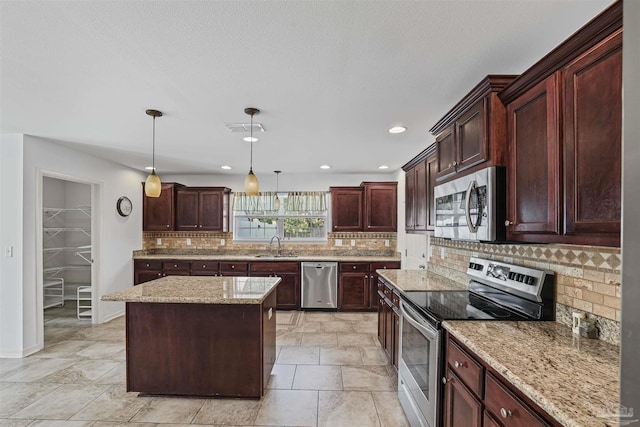4810 Endeavor Ct, Milton, FL 32570 - kitchen with stainless steel appliances, a sink, backsplash, hanging light fixtures, and light stone counters