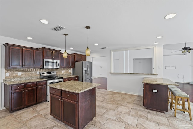 4810 Endeavor Ct, Milton, FL 32570 - kitchen featuring stainless steel appliances, a kitchen island, decorative backsplash, hanging light fixtures, and ceiling fan