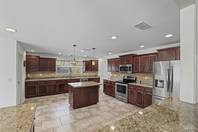 4810 Endeavor Ct, Milton, FL 32570 - kitchen featuring appliances with stainless steel finishes, a sink, decorative backsplash, light stone counters, and recessed lighting