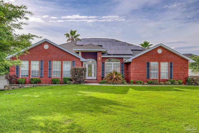4810 Endeavor Ct, Milton, FL 32570 - view of front of property with a front lawn, roof mounted solar panels, brick siding, and roof with shingles
