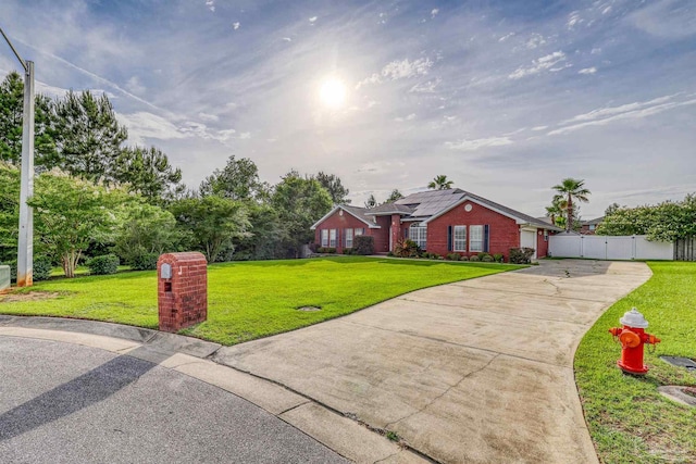4810 Endeavor Ct, Milton, FL 32570 - view of front of house with concrete driveway, roof mounted solar panels, brick siding, and a gate