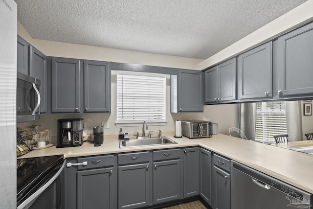 5576 Shadow Shore Pl, Gulf Breeze, FL 32563 - kitchen featuring appliances with stainless steel finishes, light countertops, a textured ceiling, and gray cabinetry
