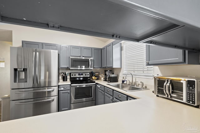 5576 Shadow Shore Pl, Gulf Breeze, FL 32563 - kitchen with stainless steel appliances, gray cabinetry, light countertops, and lofted ceiling