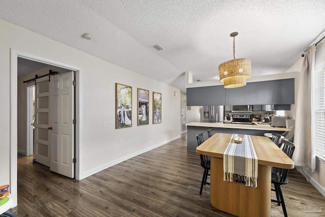 5576 Shadow Shore Pl, Gulf Breeze, FL 32563 - dining room featuring a textured ceiling, dark wood finished floors, and a barn door