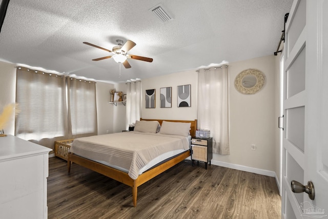 5576 Shadow Shore Pl, Gulf Breeze, FL 32563 - bedroom with dark wood finished floors, a textured ceiling, a barn door, and a ceiling fan