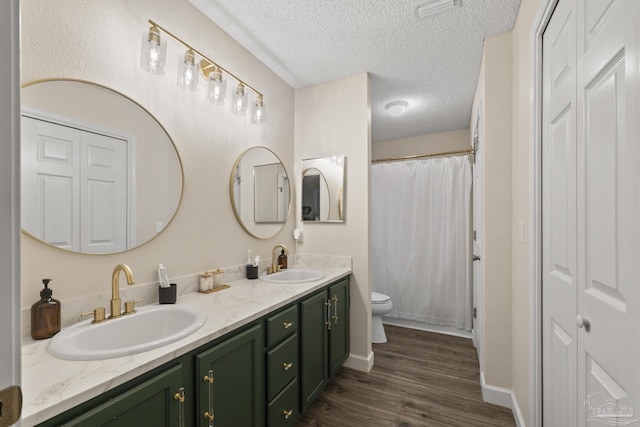 5576 Shadow Shore Pl, Gulf Breeze, FL 32563 - bathroom featuring double vanity, wood finished floors, a textured ceiling, and a shower with curtain