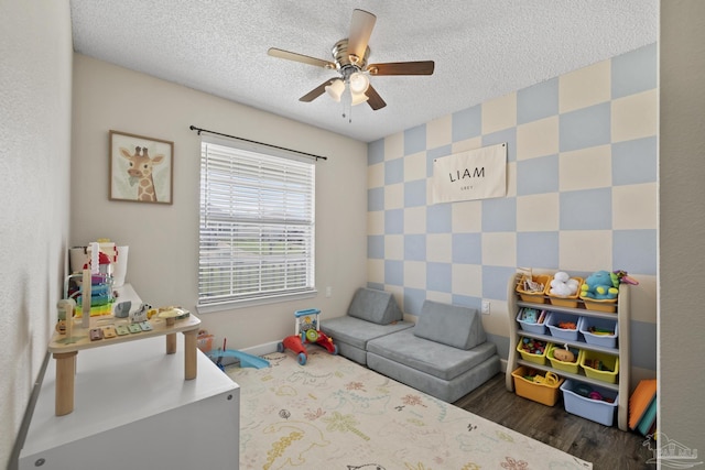 5576 Shadow Shore Pl, Gulf Breeze, FL 32563 - rec room with an accent wall, a ceiling fan, a textured ceiling, wallpapered walls, and wood finished floors