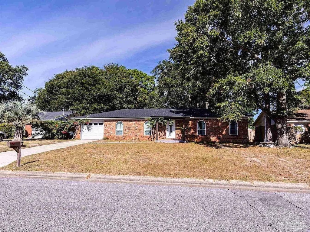 ranch-style house with a garage and a front lawn