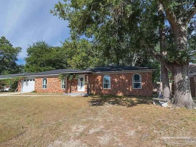 ranch-style home with a garage and a front yard