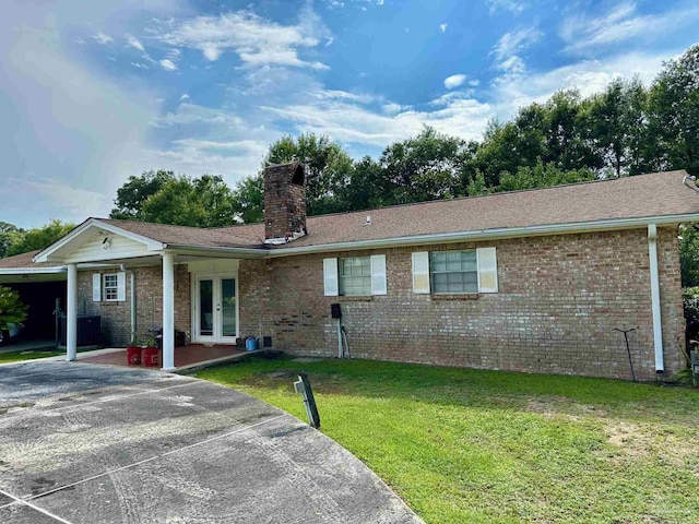 single story home with french doors and a front lawn