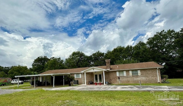 ranch-style house featuring a carport, french doors, and a front lawn