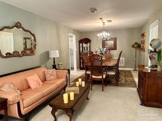 carpeted living room featuring a chandelier