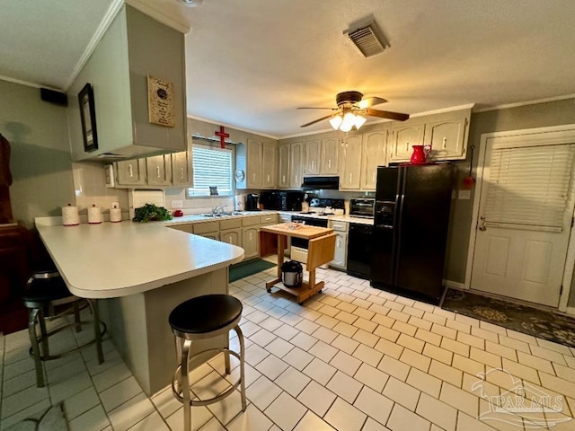 kitchen with black fridge with ice dispenser, ornamental molding, a kitchen breakfast bar, and kitchen peninsula