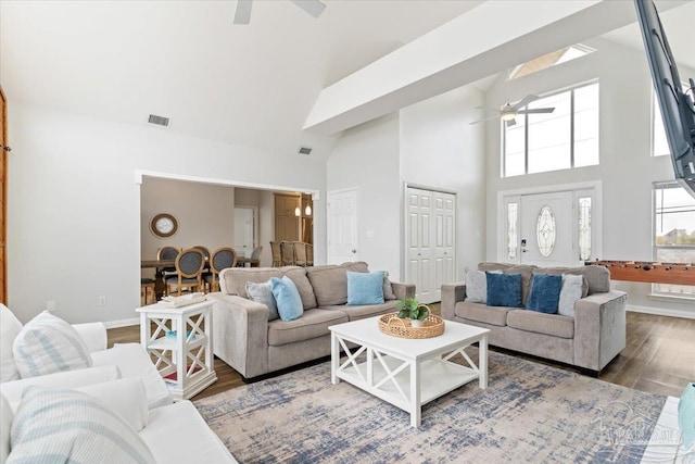 living room with ceiling fan, wood-type flooring, and high vaulted ceiling