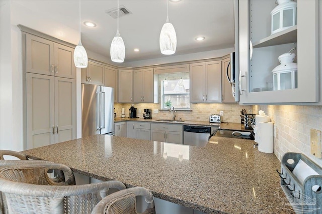 kitchen featuring light stone countertops, stainless steel appliances, a kitchen breakfast bar, and decorative light fixtures