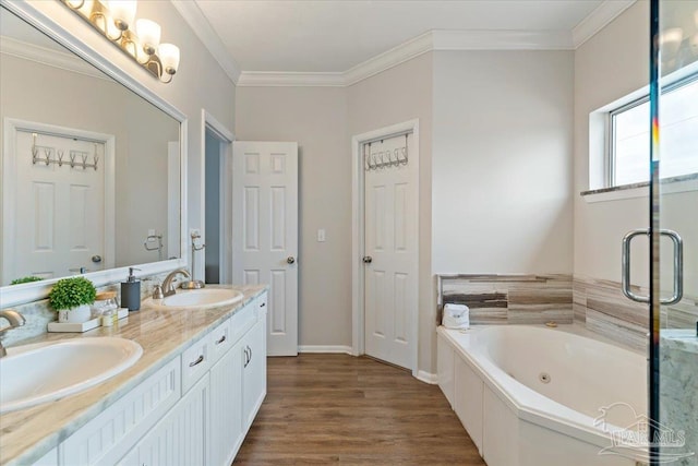 bathroom featuring wood-type flooring, ornamental molding, a bathtub, and vanity