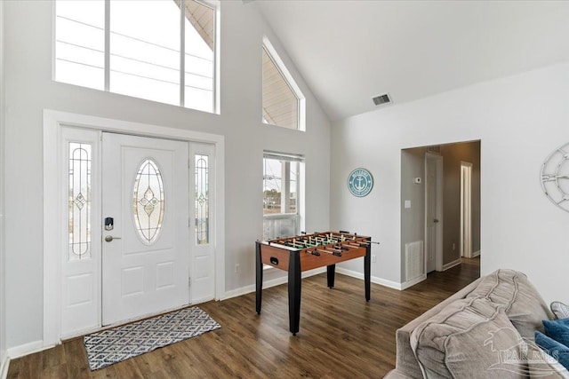 foyer entrance with high vaulted ceiling and dark wood-type flooring