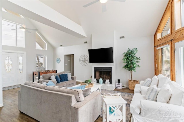 living room with a fireplace, dark hardwood / wood-style floors, high vaulted ceiling, and ceiling fan