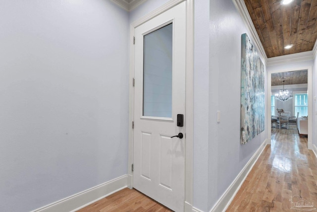 hallway featuring ornamental molding, an inviting chandelier, wood ceiling, and light wood-type flooring