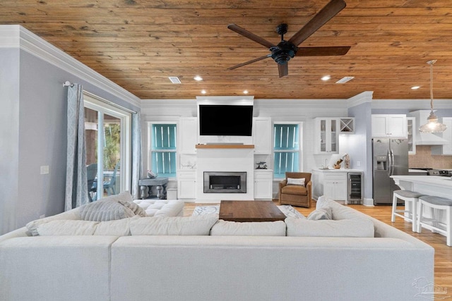 living room featuring light wood-type flooring, ornamental molding, ceiling fan, wooden ceiling, and wine cooler