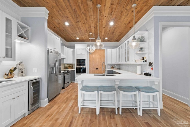 kitchen with sink, stainless steel appliances, beverage cooler, and tasteful backsplash