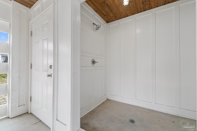 bathroom with wooden ceiling and concrete flooring