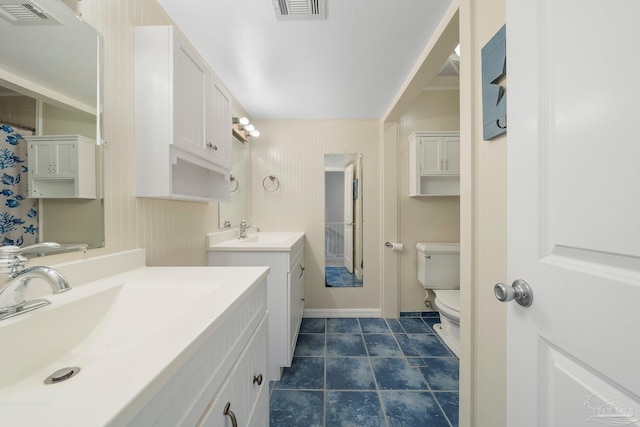 bathroom featuring toilet, tile patterned flooring, and vanity