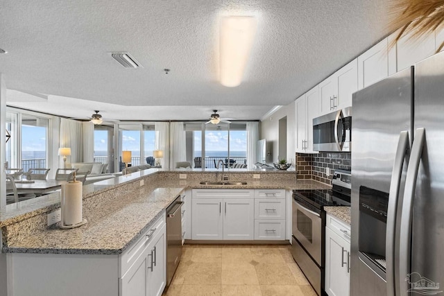375 Beach Club Trl Unit A1801, Gulf Shores, AL 36542 - kitchen with appliances with stainless steel finishes, a sink, a ceiling fan, white cabinets, and a textured ceiling