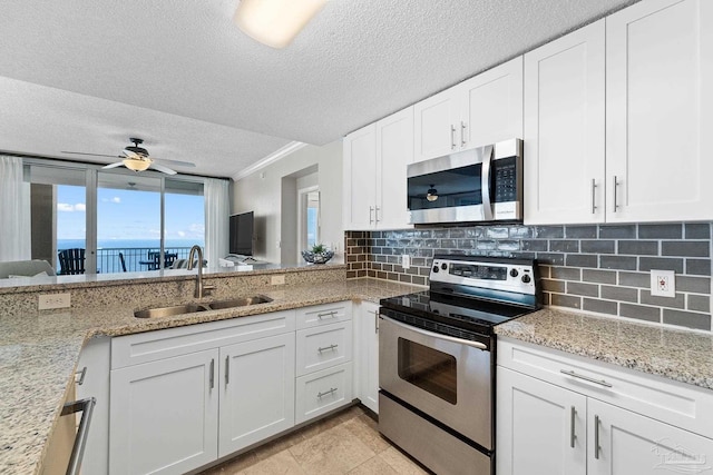 375 Beach Club Trl Unit A1801, Gulf Shores, AL 36542 - kitchen with stainless steel appliances, a sink, a textured ceiling, backsplash, and white cabinetry