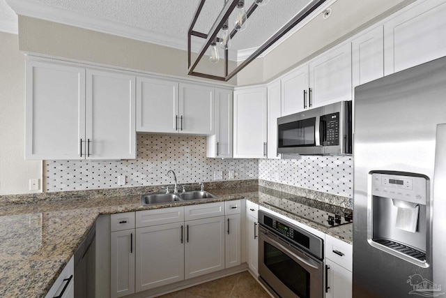 kitchen with white cabinetry, a textured ceiling, appliances with stainless steel finishes, sink, and ornamental molding