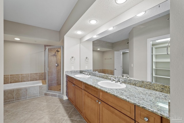 full bathroom with tile patterned floors, toilet, separate shower and tub, a textured ceiling, and vanity