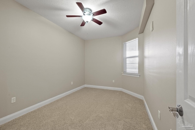 spare room with a textured ceiling, carpet, and ceiling fan