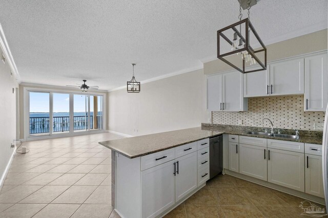 kitchen with light tile patterned flooring, ceiling fan, ornamental molding, sink, and kitchen peninsula