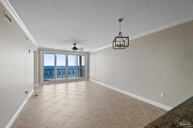 tiled empty room featuring ornamental molding, a water view, ceiling fan, and a textured ceiling