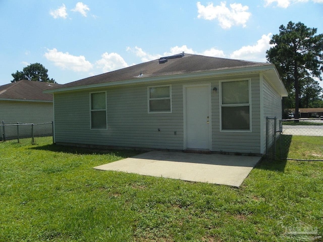 rear view of house featuring a patio, a lawn, and fence