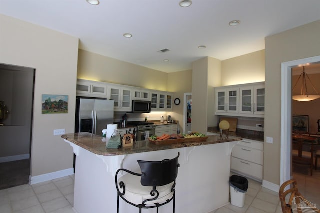 3756 Bengal Rd, Gulf Breeze, FL 32563 - kitchen with a breakfast bar area, stainless steel appliances, light tile patterned flooring, and white cabinetry