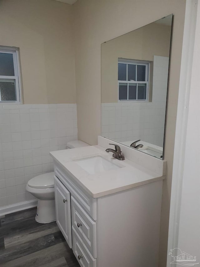 bathroom with vanity, hardwood / wood-style flooring, toilet, and tile walls