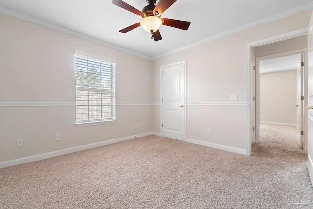 carpeted spare room featuring ceiling fan and ornamental molding