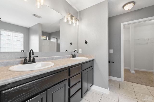 bathroom with vanity, a shower, and tile patterned floors