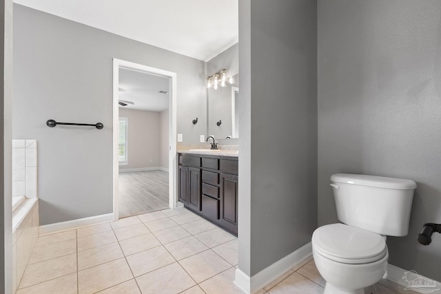 bathroom with vanity, a tub to relax in, tile patterned floors, and toilet