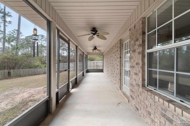 unfurnished sunroom with ceiling fan