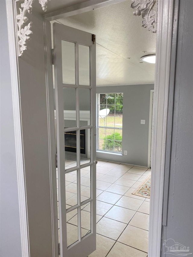 doorway with a textured ceiling and light tile patterned floors