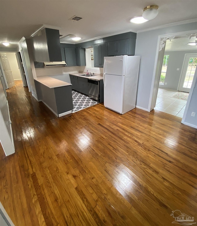 kitchen with white fridge, crown molding, dark hardwood / wood-style flooring, sink, and stainless steel dishwasher