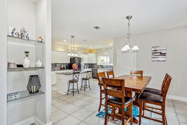 dining room featuring light tile patterned flooring and an inviting chandelier