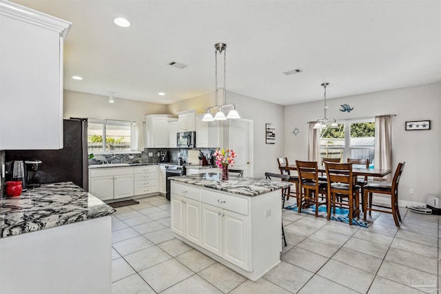 kitchen with hanging light fixtures, sink, a wealth of natural light, and white cabinetry